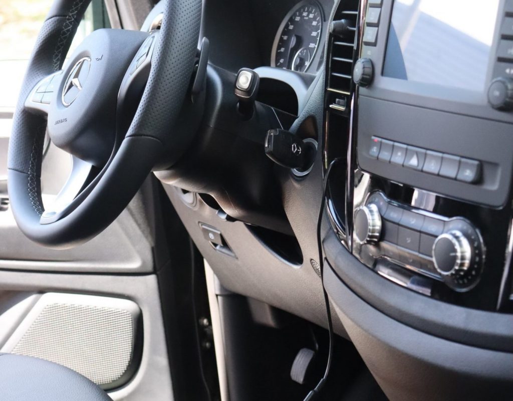 Photo de l'intérieur d'un van avec vue sur le volant, le tableau de bord ainsi que la boite de vitesse.